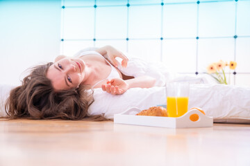Beautiful girl lies in bed and looks seductively