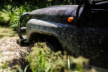 Extreme driving, challenge and 4x4 vehicles concept. Offroad race in forest. SUV or offroad car. the front of the car. driving through a deep puddle © Мария Шевцова