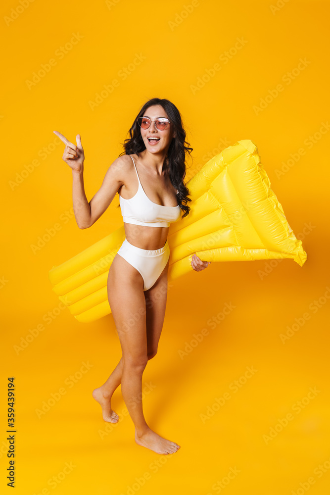 Poster image of laughing woman pointing finger aside and holding air mattress