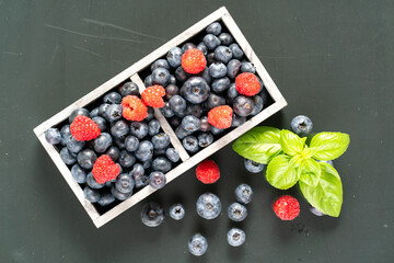 blueberries and raspberries in wooden crates.