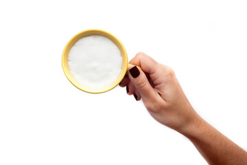 A rustic mug with coffee cream. Food art creative concept image, drawing with cinnamon powder over milk cream in a white background.