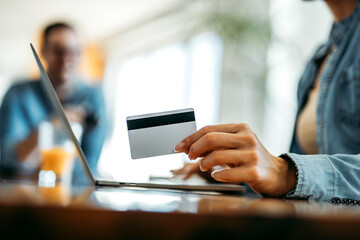 Shopping online. Woman holding credit card, close-up.
