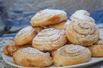 Puff pastry cakes twisted into the shape of a snail sprinkled with sugar.