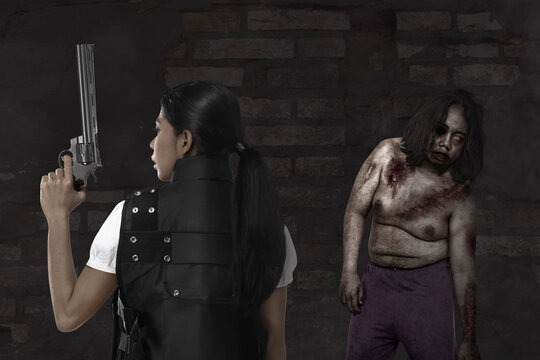 Asian woman in police vest with a gun on her hand ready to attack zombies