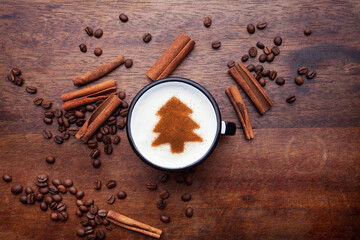 A rustic mug with coffee cream. Food art creative concept image, drawing with cinnamon powder over wooden background.