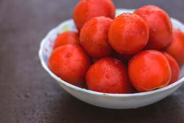 Red organic tomatoes in a bowl