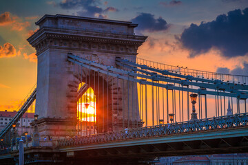 The famous Szechenyi Chain Bridge in Budapest above the Danube river, with sky illuminated by sunset, Hungary, Europe.