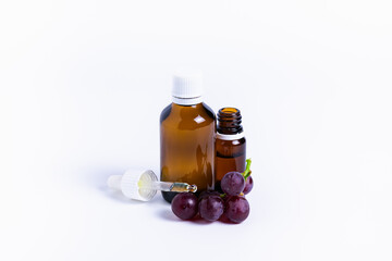 isolate bunch of grapes with a bottle of oil on a white background