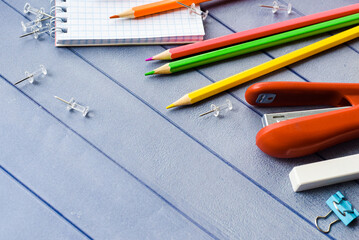 School and office supplies. Colored pencils and notebook for school and student education on blue wooden background. top view with copy space