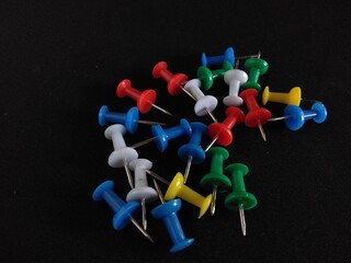colorful push pins on black background