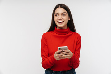 Photo of happy caucasian young woman smiling while using mobile phone