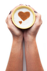 A rustic mug with coffee cream. Food art creative concept image, drawing with cinnamon powder over cream in a white background.
