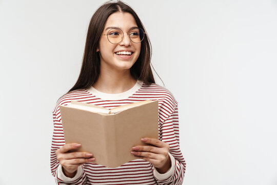 Photo of happy young woman wearing eyeglasses smiling and reading book