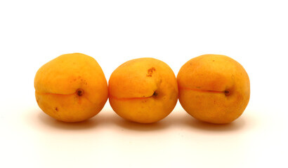 Three apricots on a light background. Natural fruits. Natural color. Close-up.