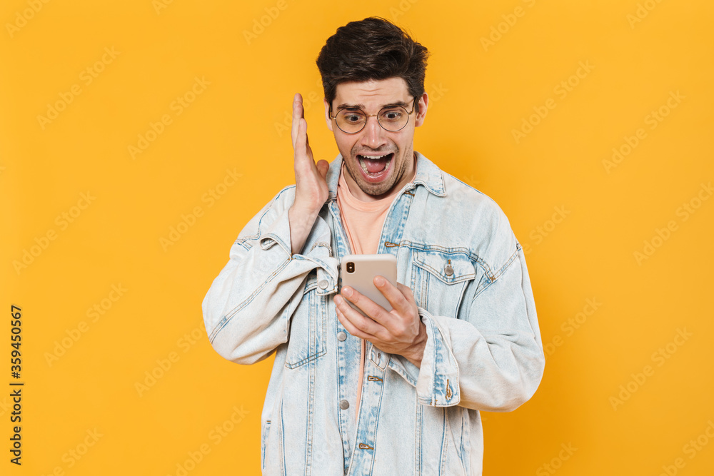 Sticker Photo of shocked young man screaming and using mobile phone