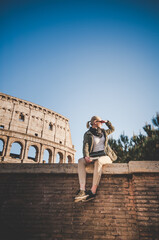 Beautiful girl at autumn sunset in front of the Colosseum in Rome, Italy