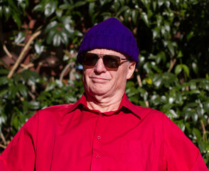 Older man in purple beanie and sunglasses  for the glare of the harsh African sun