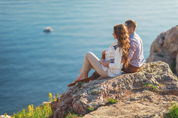 Young couple in love outdoor.Stunning sensual outdoor portrait of young stylish fashion couple posing on the background of mountains and sea
