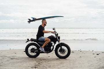 surfer on a motorcycle with a surfboard. High quality photo