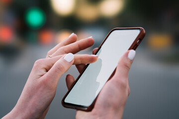 Cropped view of woman's hands holding modern smartphone with copy space area for your website and typing text message in online chat.Female finger touching blank display of digital cellular using 4G