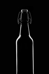 silhouette of a beer bottle on a black background. Close-up