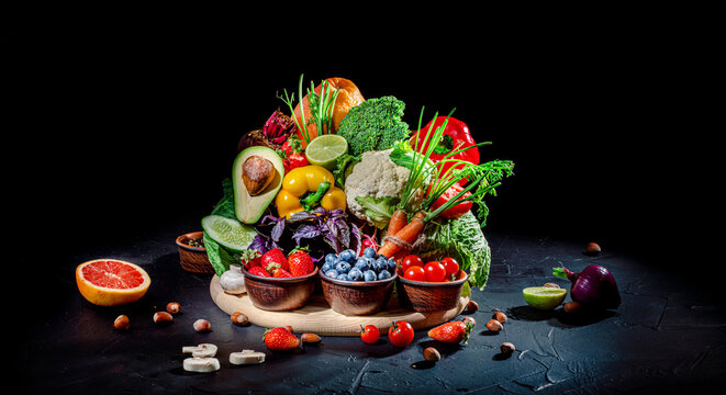 Assortment of fresh fruits and vegetables on dark background. Concept of healthy food