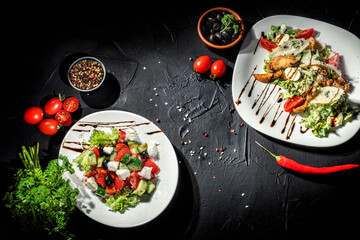 Fresh salad on a dark background. Vegetable salad from tomato, cucumber, feta cheese and olive oil