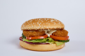Juicy burger with cucumbers, lettuce, cheese on a white background