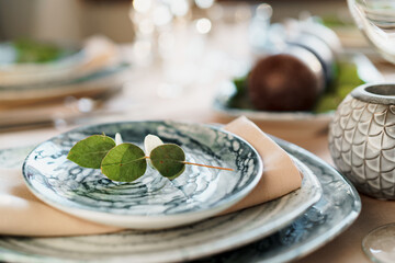 Beautiful elegant table setting with green stylish dishware and silver cutlery