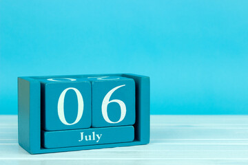 wooden calendar with the date of july 6 on a blue wooden background, World Kiss Day