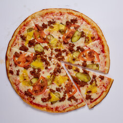 Pizza with cut off slice on a white background. Top view.