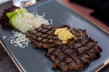 Delicious grilled steak on a ceramic plate