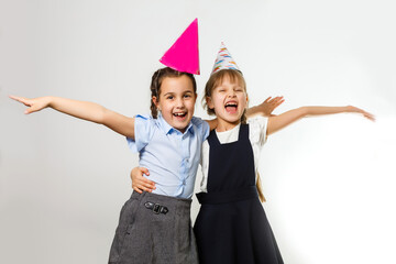 Two birthday girls in shirt blue school uniform dresses hat isolated on white background children studio portrait. Childhood kids education lifestyle concept. Mock up copy space