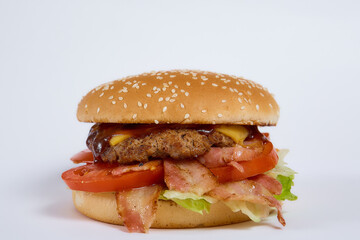 Juicy burger with cucumbers, lettuce, cheese on a white background