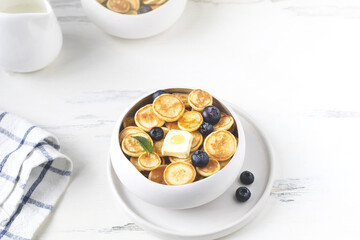 Food cooking trend, pancake cereal, tiny pancakes with raspberry, blueberry