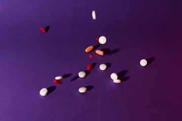 Tablets falling down on purple background.