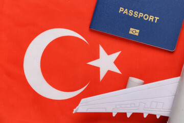 Travel concept. Passport and plane against the background of Turkish flag