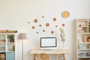 Minimal background image of contemporary home interior, focus on computer desk with wooden decor on...