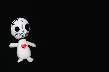 White voodoo doll with red heart laying on black background. Witchcraft, love enchantment