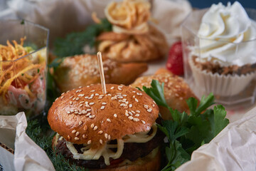 Juicy burger with onion rings, jalapeno pepper, cucumbers, lettuce, cheese on a white background