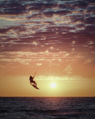 kite surfer flying over the north sea at sunset