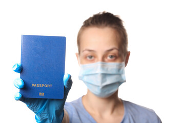 Tourism concept during the covid-19 pandemic. Immunity passport. Woman in a medical mask holds a passport isolated on white background