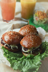 Juicy mini burgers with onion rings, jalapeno pepper, cucumbers, lettuce, cheese on a white background