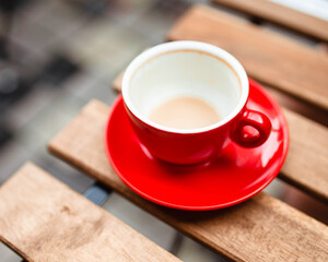 Hot coffee with latte art in a white cup with saucers on a wooden table. Cappuccino with foam. Cup of coffee on a wooden table. Top view. Place for text. Cappuccino with latte.