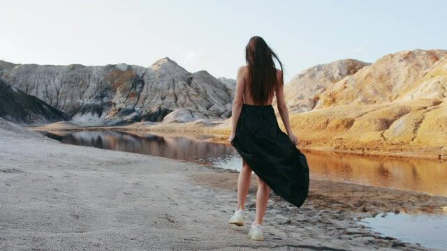 Beautiful woman walking on other-worldly hilly landscape