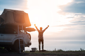 adventurer man in journey travel with off road car and roof tent to enjoy freedom and explorer...