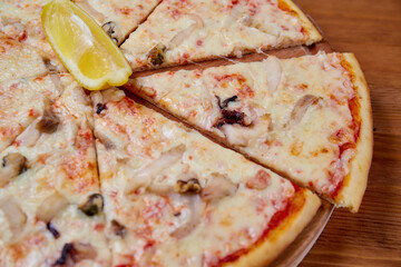 Pizza with ingredients on a wooden background. Close-up