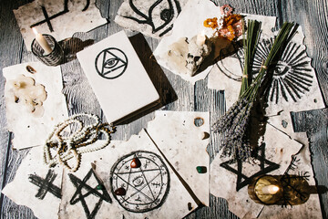 White magic book laying on the table with old manuscripts with occult symbols, candles, lavender....