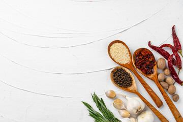 Red chili peppers and other spices on white textured background, top view