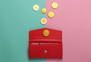 Leather wallet with coins on pink blue background. Top view